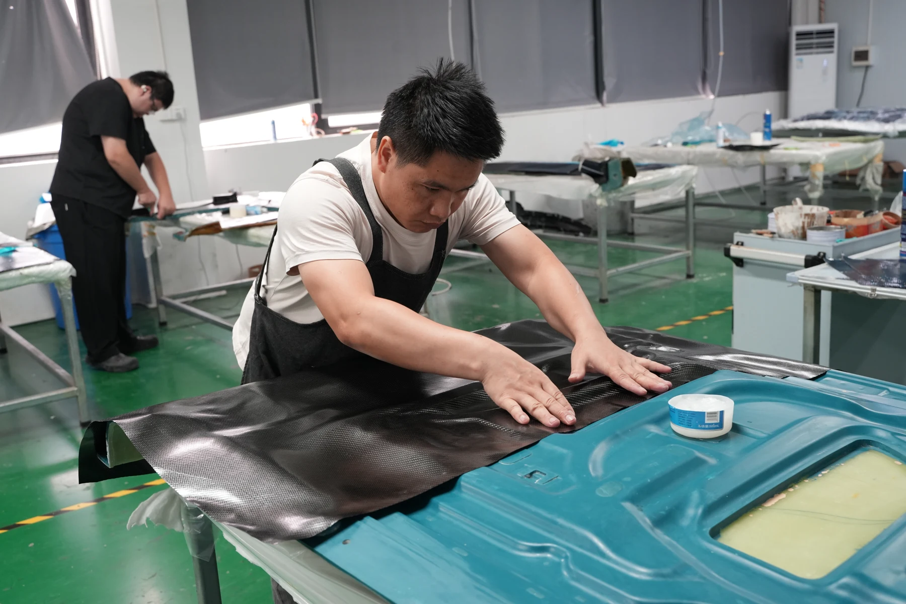 Hand setting the vacuum film over flow mesh on a laid-up carbon part