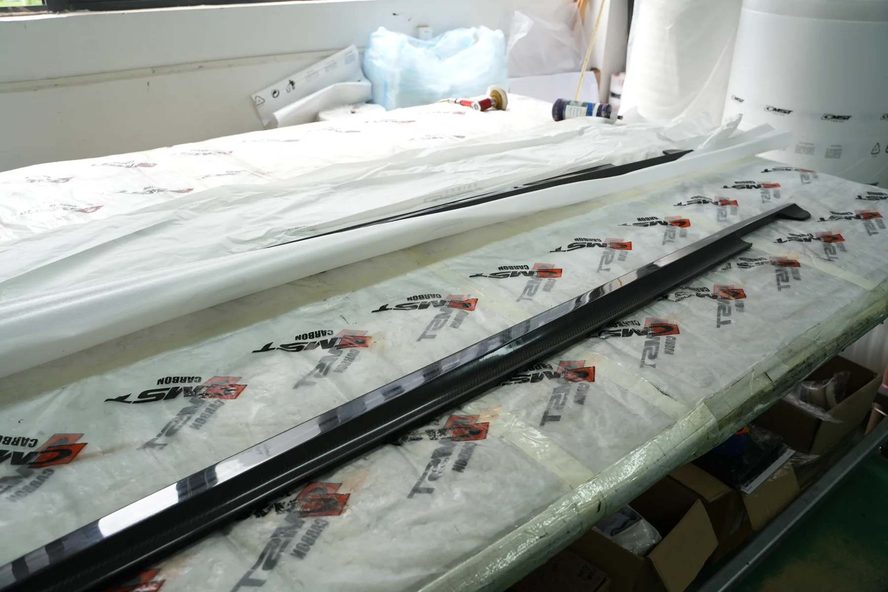 Finished CMST side skirts wrapped in CMST-branded protective film, ready to ship
